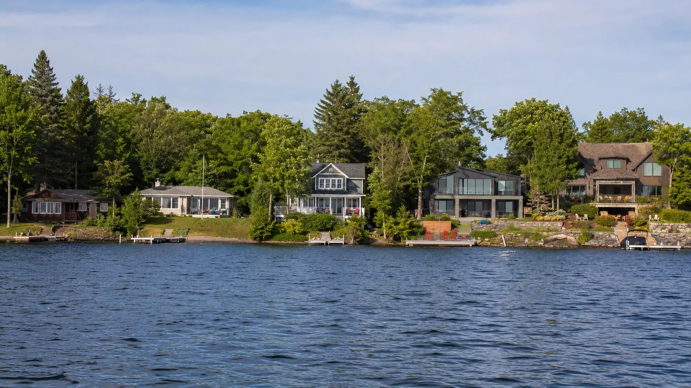 A range of lakeshore homes seen from the water, illustrating what an Orillia home valuation must account for (AI-generated image)