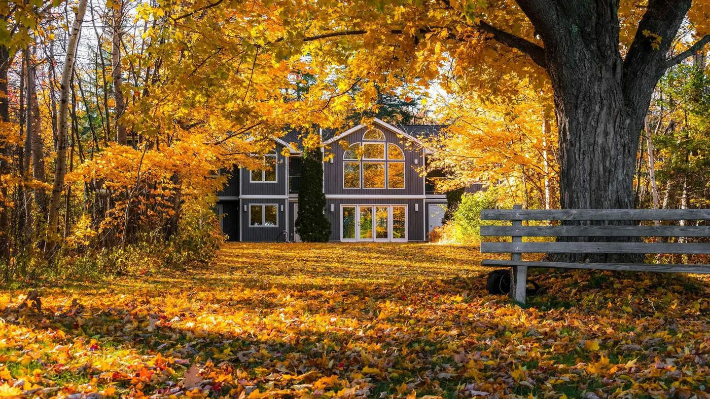 House surrounded by golden autumn foliage and fallen leaves, illustrating the best time to list in Midland