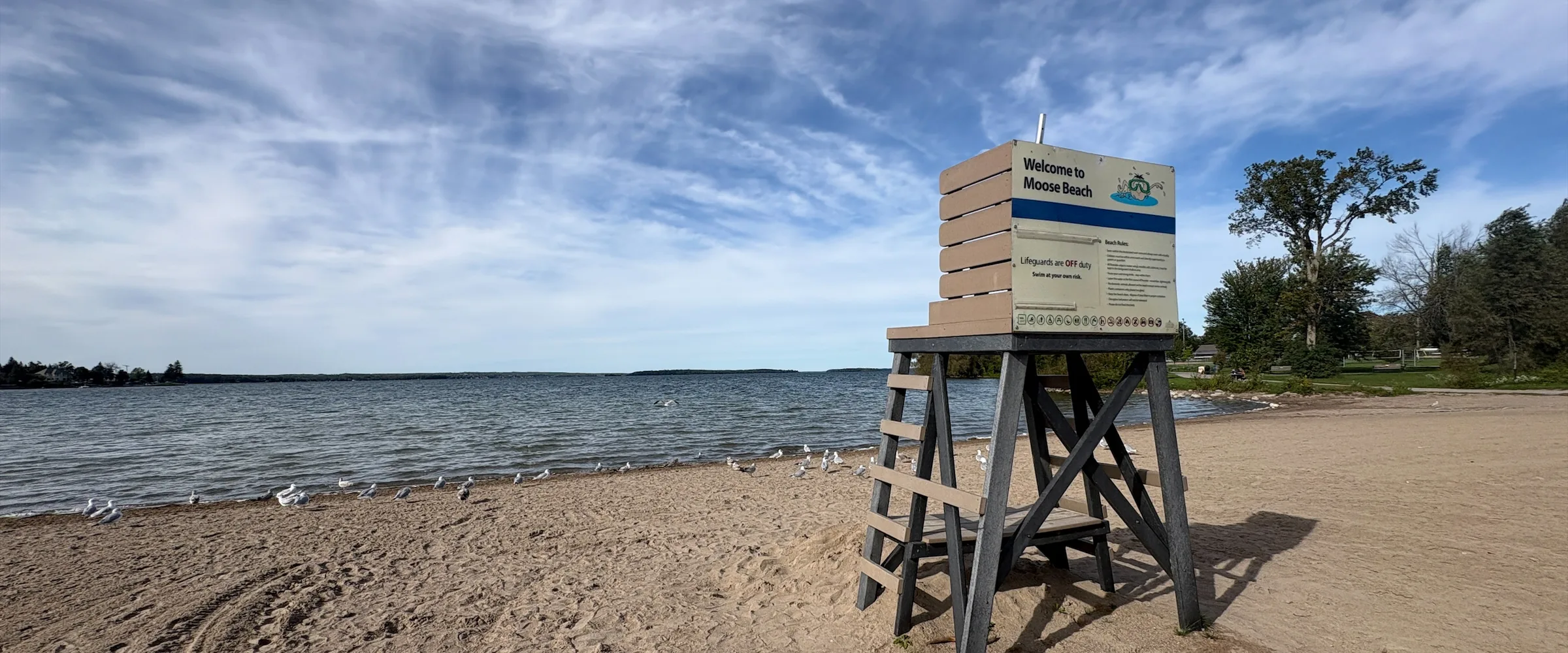 Sandy public beach, lifeguard stand and open water at Moose Beach in Orillia, Ontario